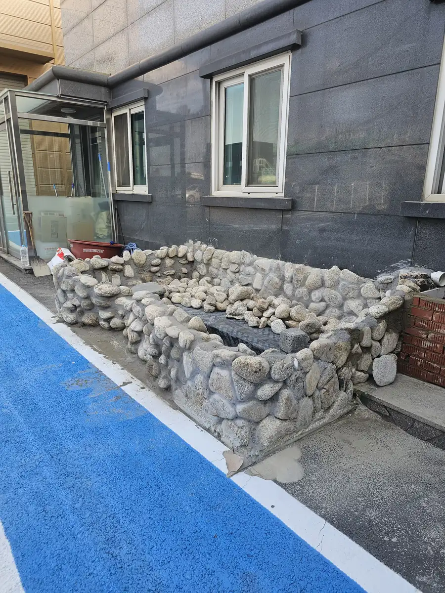 거푸집을 걷어 낸 뒤 돌쌓기 마감이 드러난 석축 수조 측면 완료 모습