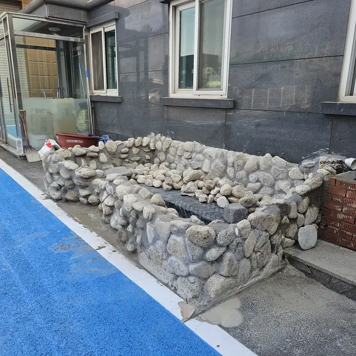 석축 수조 조성 완료 후 건물 옆 돌쌓기 마감 모습